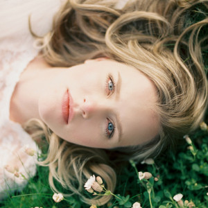 Sunkissed bride laying on edge of the Cliffs of Moher in Ireland.